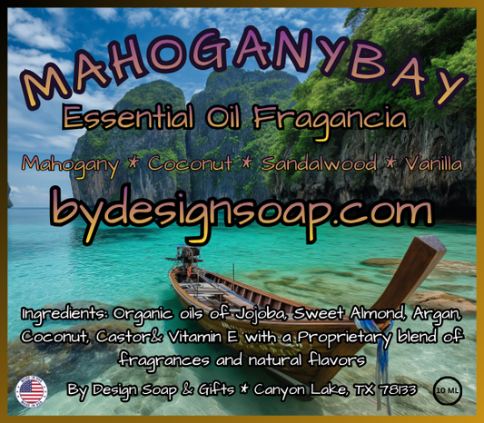 Advertisement for 'Mahogany Bay' Essential Oil Fragrance made with Mahogany, Coconut, Sandalwood and Vanilla scents with a scenic background of a tropical island, turquoise water and fishing boat. MADE IN THE USA LABEL.