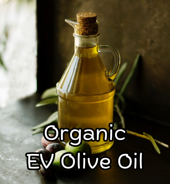Bottle of organic olive oil with a cork lid on a dark surface with green leaves with the text 'Organic EV Olive Oil'.