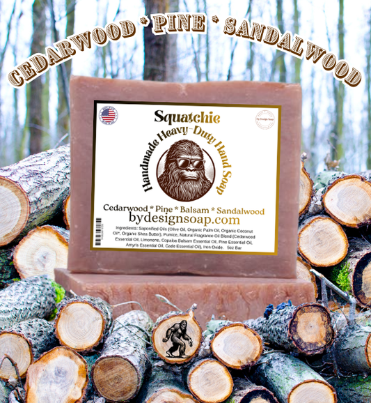 Advertisement for 'SQUATCHIE' handmade hand soap made with Cedarwood, Pine and Sandalwood scents with a background of wooden logs and a forest scene. MADE IN THE USA LABEL.