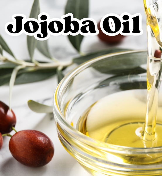 Jojoba oil being poured into a glass bowl with jojoba berries and leaves in the background.